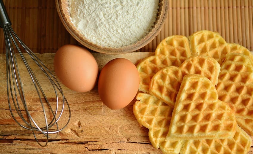 Ein WMF Schneebesen liegt neben frischen Waffeln
